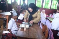 Wali Kota Eva Dwiana bercengkerama dengan seorang murid seputar menu MBG yang disajikan. (Foto: ist)