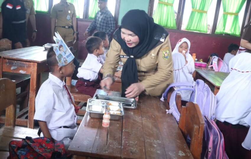 Wali Kota Eva Dwiana bercengkerama dengan seorang murid seputar menu MBG yang disajikan.