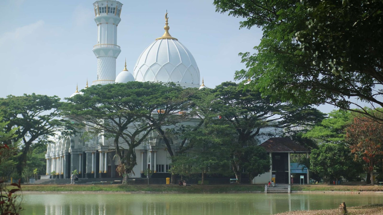 Keindahan Masjid Safinatul Ulum UIN Raden Intan berpadu telaga dan rindang pepohonan.